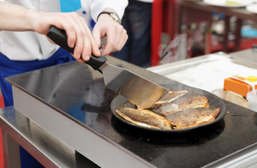 Chef frying seabass fillet