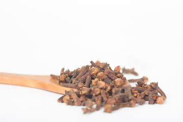 Dry cloves in wooden spoon on white background. Cloves help in improving the immune system.