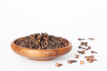 Cloves in wooden bowl on white background. Cloves have anti-carcinogenic properties.