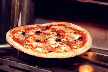 Taking a pizza out of oven, toned