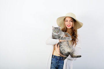 Positive smiling woman holding cat on white background