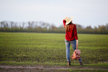 Woman standing back in field, natural background