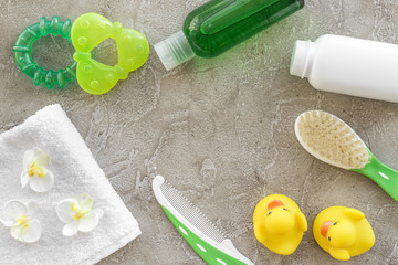 Baby care with bath set, ducklings and towel on gray background top view mockup