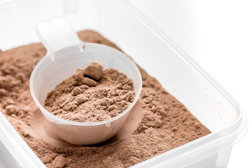 Fitness nutrition with scoop on white background