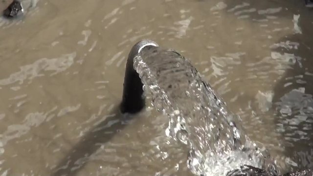 A lot of water is coming through a pipe that is broken. Water leak on a road of Taipei City, Taiwan.