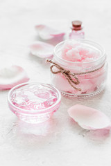 cosmetic set with rose blossom and body cream on white desk background