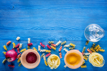 Fototapeta na wymiar Food ingredients for Italian pasta on blue wooden desk background top view copyspace