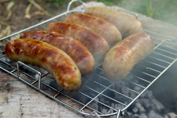 Pork sausage fry on charcoal with smoke