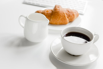 Business breakfast in office with milk, coffee and croissant on white table background