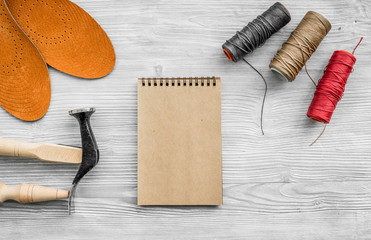 Cobbler takes order. Notebok on grey wooden desk background top view mockup