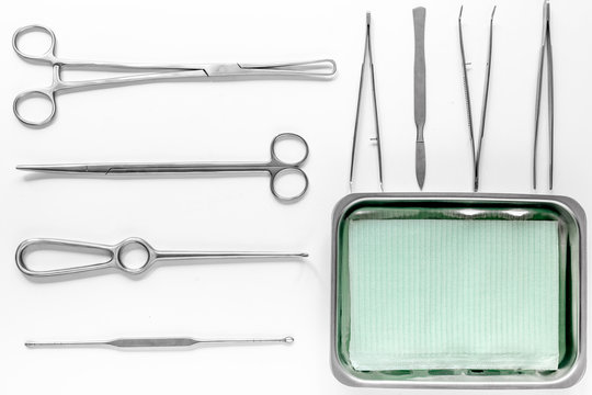 Surgical instruments and tools including scalpels, forceps and tweezers on white table top view mock up