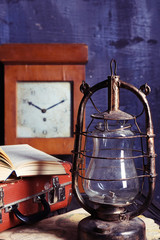 Obraz na płótnie Canvas vintage travel still life with kerosene lamp, book and suitcase 