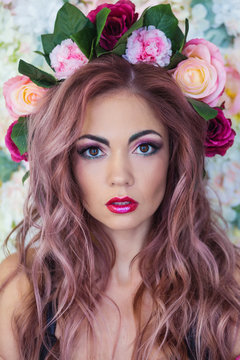 Portrait of a girl with bright make-up and flowers in her hair
