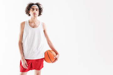 Serious thin guy playing basketball