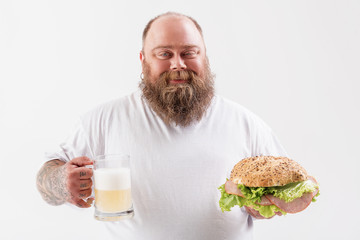 Man holding alcohol beverage with sandwich