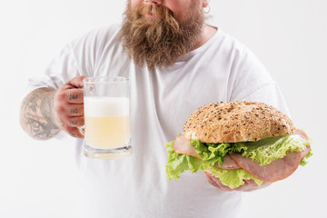 Man holding a sandwich and a drink in both hands