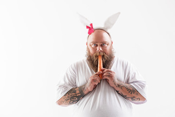 Man eating carrot wearing rabbit ears