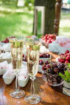 Festive table setting wineglasses with champagne, fruit and marshmallows. Wedding decor.