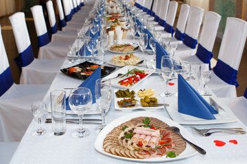 Served with Cutlery and a food table. A Banquet with food and snacks with a luxurious setting on a white tablecloth.