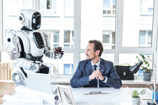 Robot-assistant is bringing beverage for smiling employee