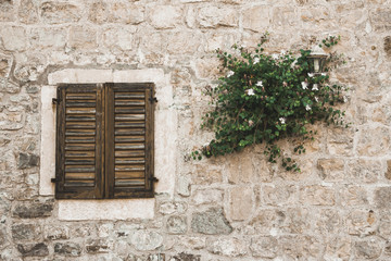 Fototapeta na wymiar Montenegro old town rocky brick wall wooden window facade.
