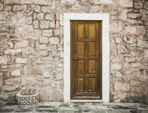 Montenegro old town brick wall with wooden door background.