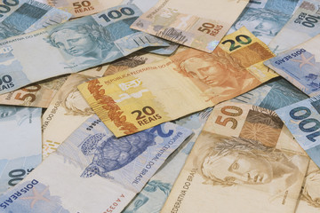 Obraz na płótnie Canvas Brazilian money background. Bills called Real, different values. Economy of Brazil concept image.