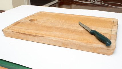 Old chopping board and knife isolated on white background