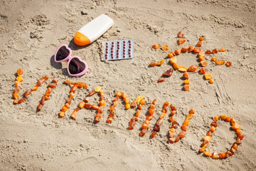 Medical pills, inscription vitamin D and accessories for sunbathing at beach, prevention of vitamin...