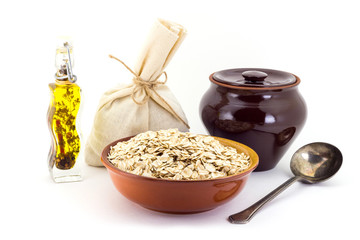 The composition of the Oatsmeal groats in a clay pial next to a clay pot and a copper spoon,