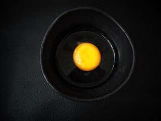 Egg in a bowl on black background