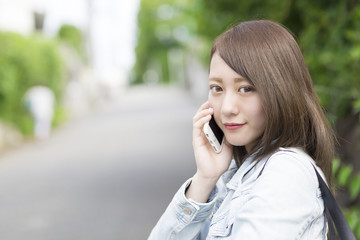 スマホを持つ　振り返る女性　屋外