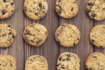 Oat cookies with chocolate drops on brown wooden background