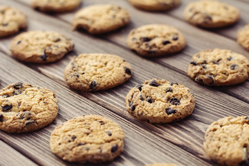 Oat cookies with chocolate drops on brown wooden background