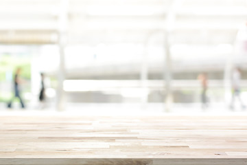 Wood table top on white blur abstract background from outdoor covered walkway in the city