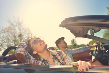 Couple of lovers driving on a convertible car - Newlywed pair on a romantic date