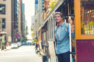 San Francisco hipster man taking public cable car transport for tourism travel. University student...