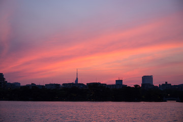 Obraz premium Time lapse of beautiful, urban sunset and cloudscape over skyscraper 