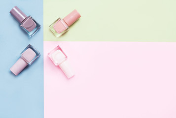 Creative flat lay of fashion bright nail polishes on a colorful background. Minimal style. Copy space. Beauty blogger concept. Top view