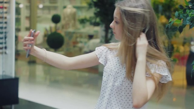 Close-up a nice girl of 13 years photographing herself using a smartphone, Selfie
