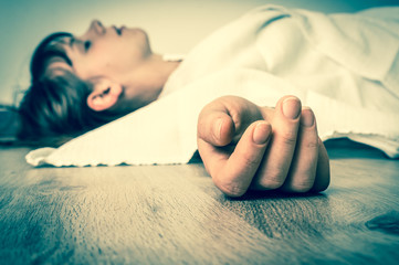 Dead woman lying on the floor under white cloth