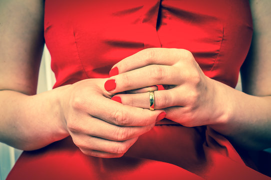 Woman is taking off her wedding ring - divorce concept