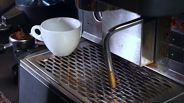 Video footage of man hands making a cup of hot coffee with coffee machine in the cafe kitchen