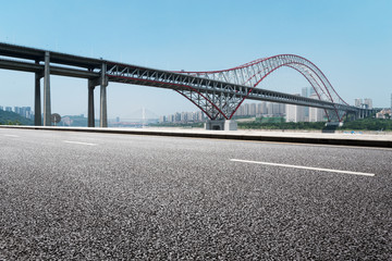 empty road near steel bridge in modern city