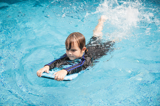 Boy playing in outdoor swimming pool,Kids learn to swim.