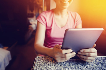 girl is working on a computer tablet, smiling and typing text on a train and train journey in the car. The concept of social mobility and technology.