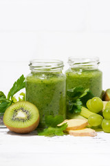 green fruit and vegetable smoothies in jars, vertical