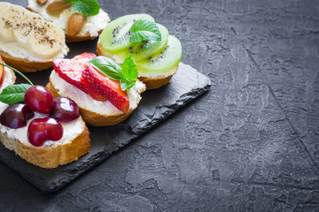 Assorted summer sweet snacks. Bruschetta or sandwiches with fruit and berries.