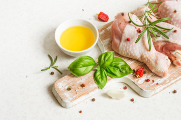 Raw chicken drumstick on a cutting board with spices prepared for cooking. copy space