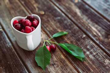 Cherries in heart cup of tea